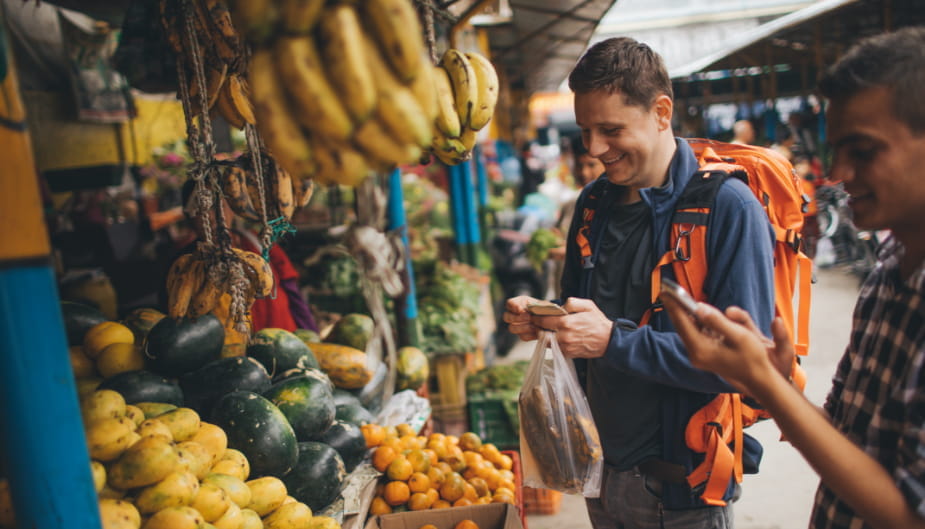 Viajero comprando comida en el mercado, con intestino sano