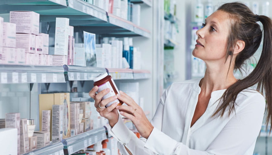 Woman choosing between probiotics products
